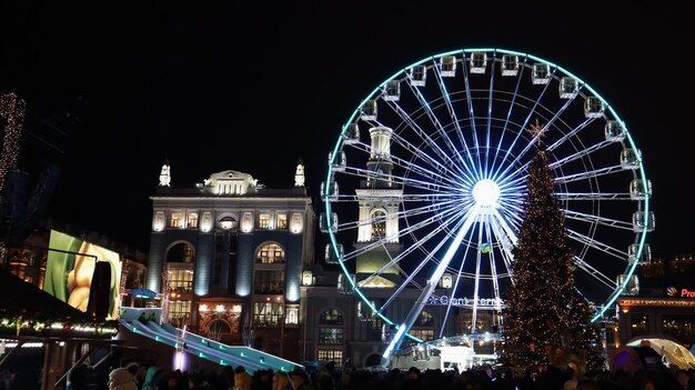 Ukraine, Kiew - 15. Januar 2019. Beleuchtetes Riesenrad auf dem Kontraktova-Platz in Kiew am Abend.