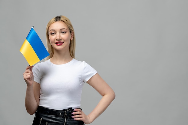 Ukraine russischer Konflikt blondes süßes Mädchen mit rotem Lippenstift und ukrainischer Flagge mit der Hand auf der Taille