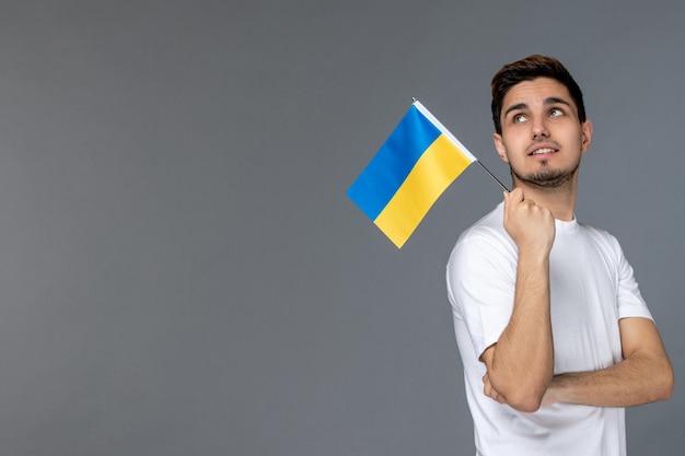 Ukraine-Russland-Konflikt tapferer, süßer, gutaussehender Kerl im weißen Hemd mit ukrainischer Flagge