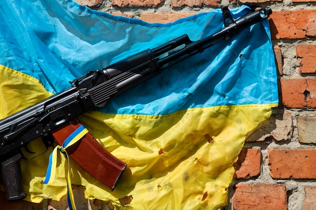 Ukrainische Flagge an der Wand mit Gewehr