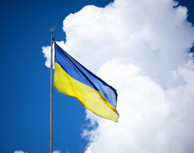 Ukrainische Flagge auf dem Hintergrund des Himmels mit einer Wolke