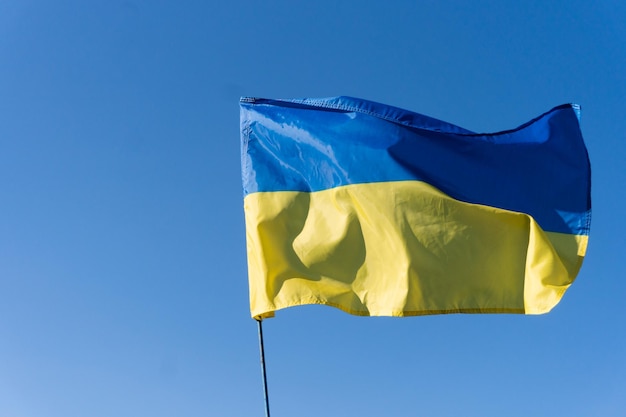 Ukrainische Flagge auf einem Fahnenmast blauen Himmelshintergrund