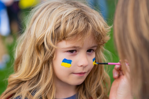 Ukrainische Flagge auf Kinderwange menschlicher Protest