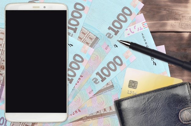 Ukrainische Griwna Rechnungen und Smartphone mit Geldbörse und Kreditkarte
