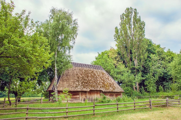 Ukrainische Hütte, die abfallendes Feld in der Nähe mit Stroh bedeckt