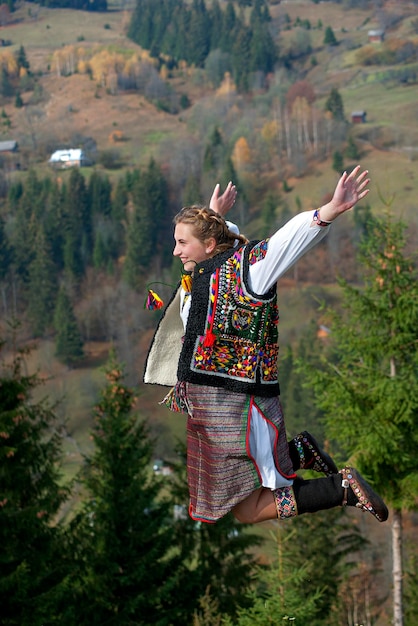 Ukrainische Hutsul-Frau in authentischer Tracht fliegt in den Bergen.