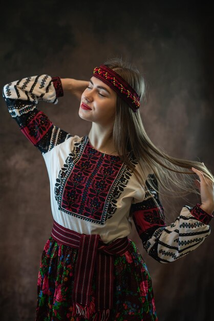 Ukrainische junge Frau trägt traditionelle ukrainische Vyshyvanka-Kleidung auf schwarzem Hintergrund