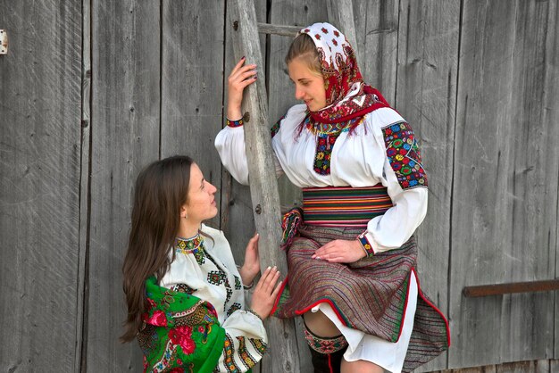 Ukrainische Mädchen in traditioneller huzulischer Kleidung führen ein interessantes Gespräch.