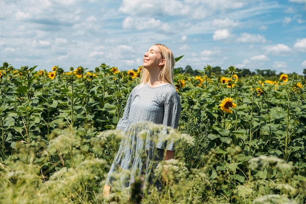 Ukrainische Mädchen junge Frau auf dem Hintergrund des Sonnenblumenfeldes nationales Symbol der ukrainischen Sonnenblumen