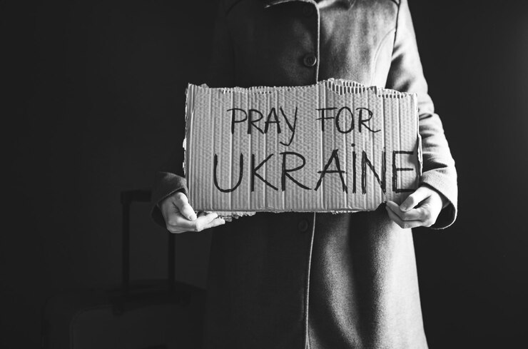 Foto ukrainischer flüchtling hält ein plakat mit dem text "beten für die ukraine" in der hand evakuierung von zivilisten freiheit in die ukraine konzept
