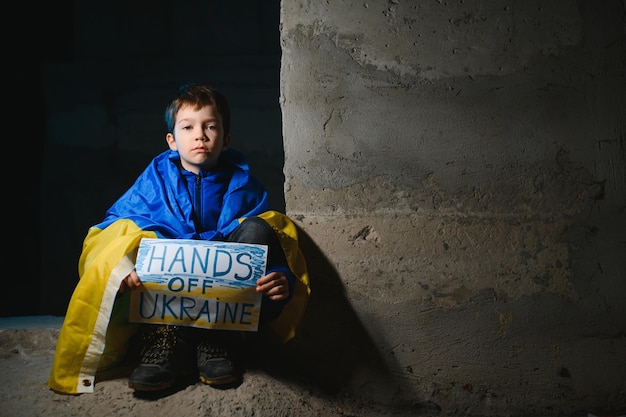 Ukrainischer junge hält eine gemalte flagge der ukraine krieg russlands gegen die ukraine der ukrainische weinende junge bittet darum, den krieg in der ukraine zu stoppen