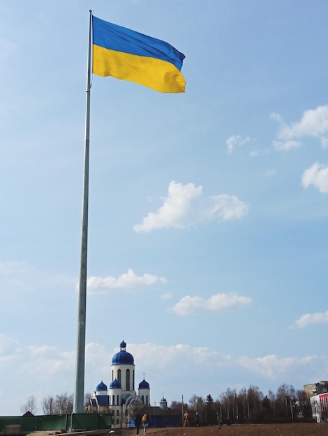 Ukrainisches Nationalflaggensymbol, das im blauen Himmel flattert Große gelbblaue ukrainische Staatsflagge