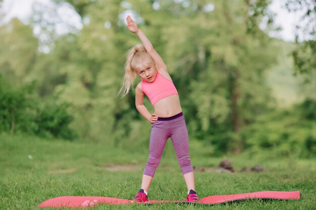 Ukrainisches schönes 7-jähriges Mädchen mit weißen Haaren wie ein Engel beschäftigt sich mit Fitness