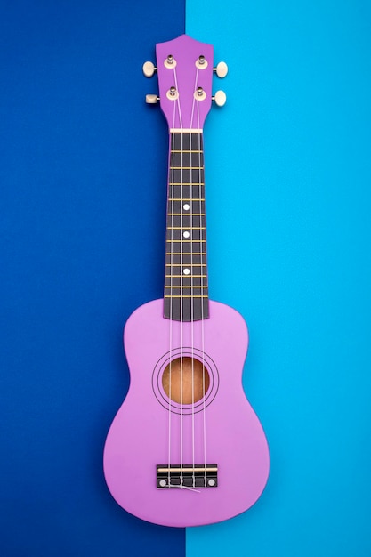 Ukulele-Gitarre mit vier Saiten auf blauem Hintergrund