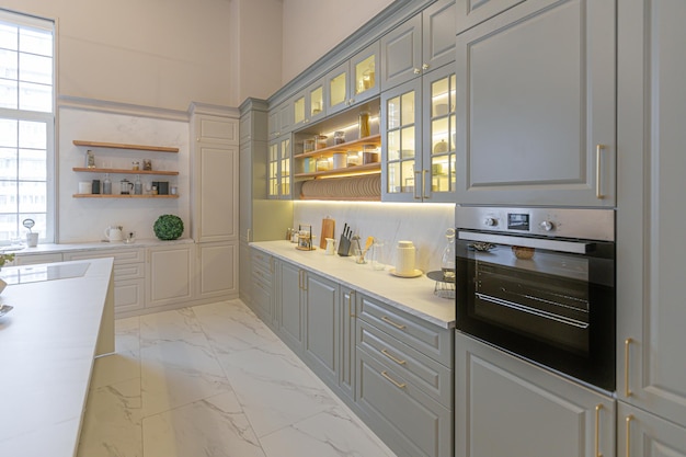 Las últimas tendencias de moda para el hogar en un interior ultramoderno y elegante de un acogedor estudio en suaves colores pastel primeros planos de una elegante cocina con una isla para cocinar