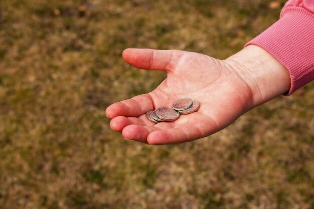 El último dinero para las compras Monedas en la mano de una mujer de mediana edad El concepto de la crisis alimentaria mundial