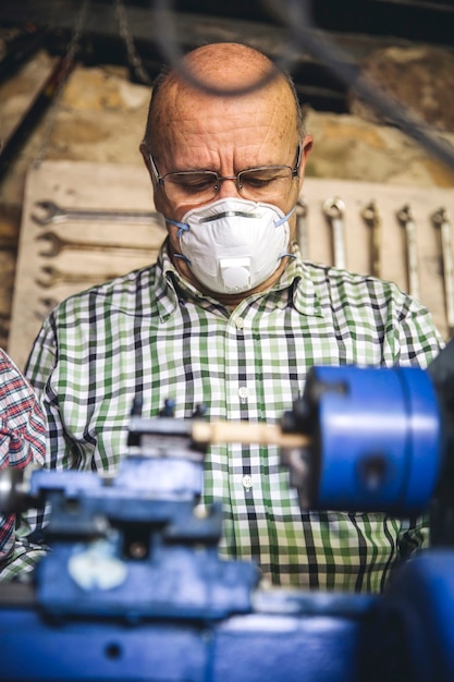Último homem com máscara protetora trabalhando em uma oficina de carpintaria
