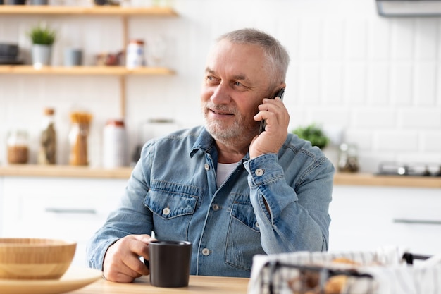 Último homem falando ao telefone, sentado à mesa em casa