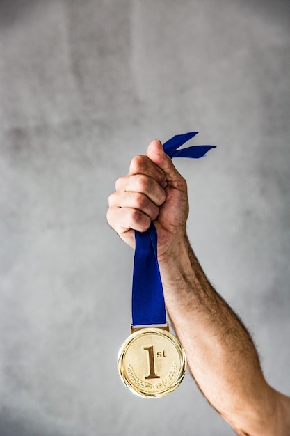 Foto Último homem segurando a medalha na mão. conceito de vitória e sucesso