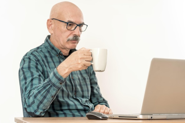 Último homem tomando café e trabalhando com um laptop em casa