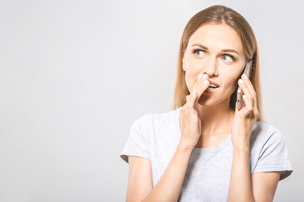 Ultra secreto! Retrato de mulher de negócios jovem bonita usando telefone celular isolado no fundo branco