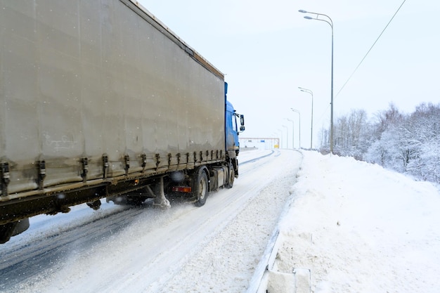 Ulyanovsk Rusia 13 de febrero de 2022 Un camión semirremolque y un semirremolque para transportar carga Transporte de carga en duras condiciones invernales en carreteras resbaladizas heladas y nevadas