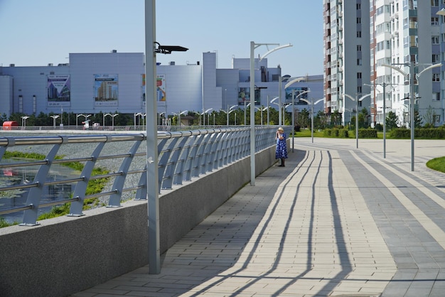 Ulyanovsk Rússia 25 de julho de 2022 Uma mulher observa patos selvagens na água no aterro do rio Sviyaga