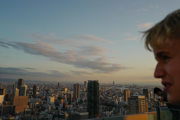 Foto um adolescente a olhar para a paisagem da cidade.