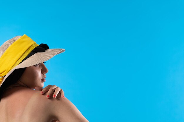 Um adolescente com um grande chapéu de praia segura uma mão em um ombro bronzeado