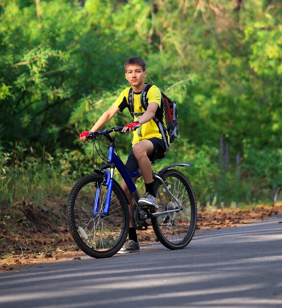 Um adolescente em uma bicicleta viajando na floresta