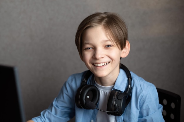 Um adolescente está sentado em casa no computador e jogando jogos de computador online.