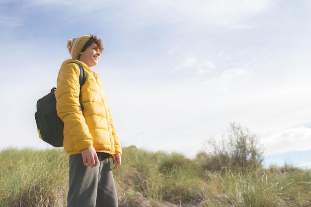 Um adolescente olhando para o horizonte, sonhando com um futuro próspero