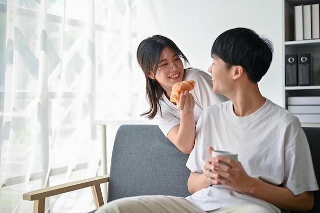 Um adorável jovem casal asiático está passando um tempo juntos na sala de estar