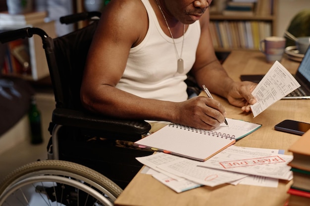 Um afro-americano aposentado com deficiência a trabalhar com contas em casa
