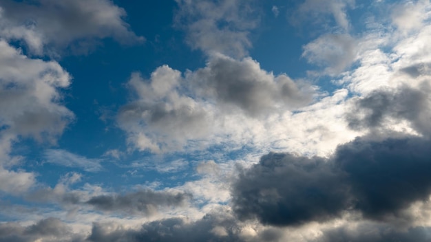 Um aglomerado de nuvens leves e fofas intercaladas com nuvens cinzentas escuras Antes da chuva e da tempestade