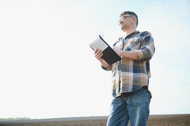 Um agricultor verifica a qualidade do solo antes de semear