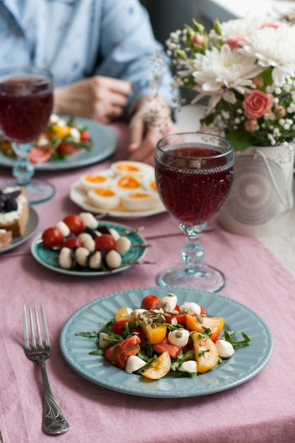 Um almoço gourmet para dois: salada, canapés, ovos cozidos e vinho.