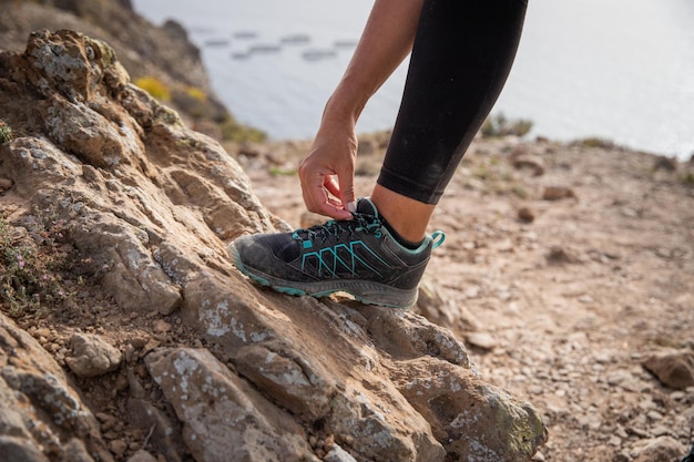 Foto um alpinista está amarrando os sapatos perto do pé