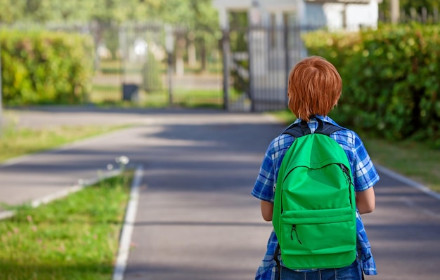 Um aluno com uma mochila vai para a escola primária, uma criança da escola primária, volta para a escola.