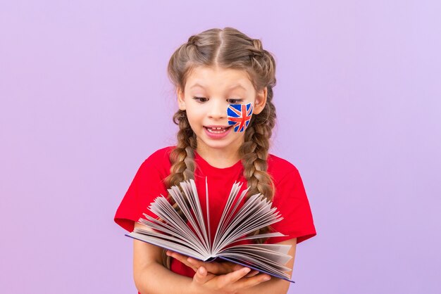 Um aluno está estudando um livro de inglês sobre um fundo roxo isolado. Aprendendo idiomas extrangeiros.