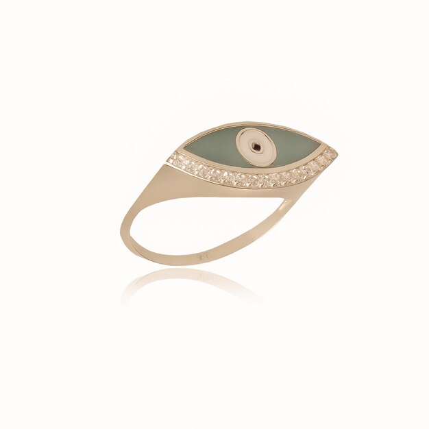 Um anel de ouro com um olho verde e um diamante no fundo.
