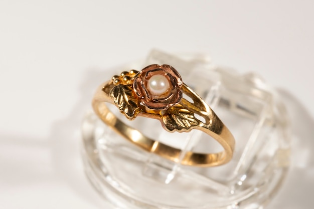 Um anel de ouro com uma pequena pérola. modelo de anel black hills, folhas de uva e cachos