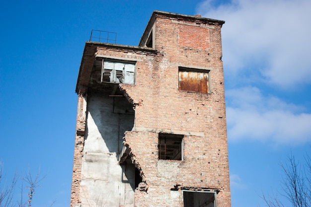 Um antigo edifício abandonado. Construção arruinada de tijolos vermelhos.