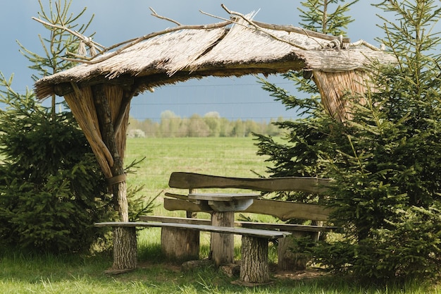 Um antigo gazebo de madeira para relaxar no parque Equipado com mesas e bancos de madeira