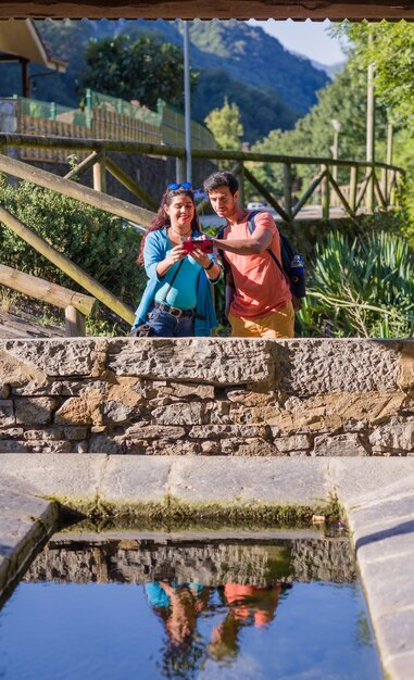 Um antigo lavatório ecológico. Um casal de raça mista a fotografar com um smartphone.