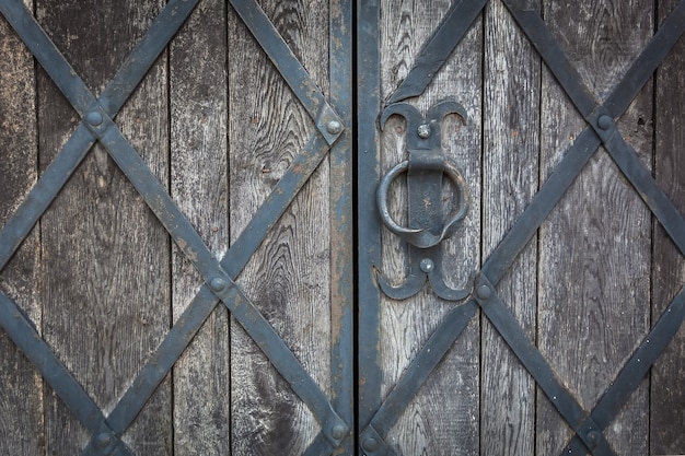 Foto um antigo portão de madeira é decorado pela grade forjada