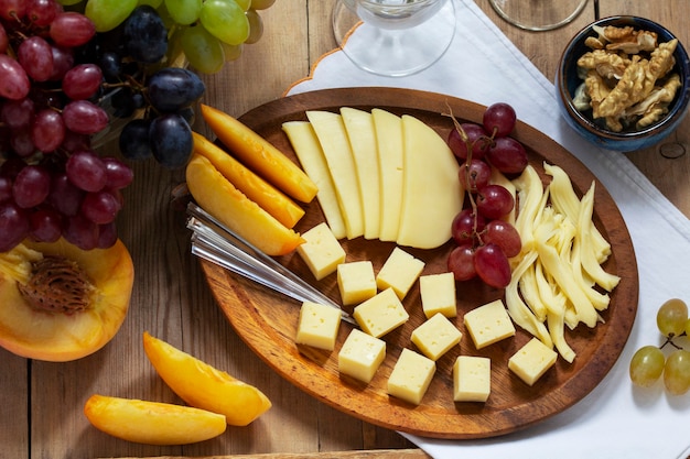 Um aperitivo de vários tipos de queijos, uvas e nozes, servido com vinho. estilo rústico.