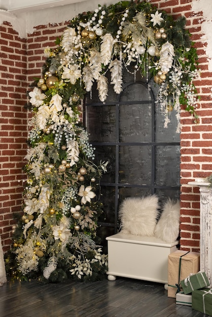 Um arco de natal com flores brancas e uma caixa de presentes de natal