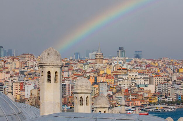 Foto um arco-íris é visto sobre uma cidade com uma cidade no fundo