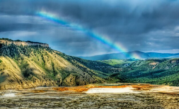 Foto um arco-íris está no céu acima de uma montanha